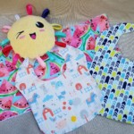 two bibs a burp cloth and sunny plush toy